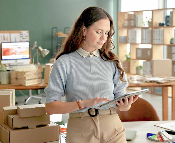 Vendere nel Regno Unito 4 Imprenditrice gestisce vendite online nel Regno Unito da ufficio con pacchi e tablet