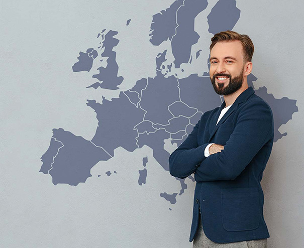 Vendere online in Europa 1 Imprenditore sorride davanti a una mappa dell’Europa, pronto a vendere online in UE