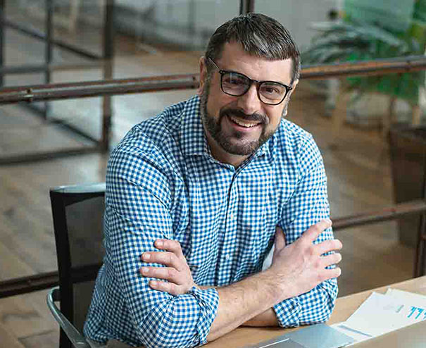 Partita IVA Olanda 2 Consulente sorridente in ufficio moderno, simbolo di esperienza professionale e supporto fiscale su misura