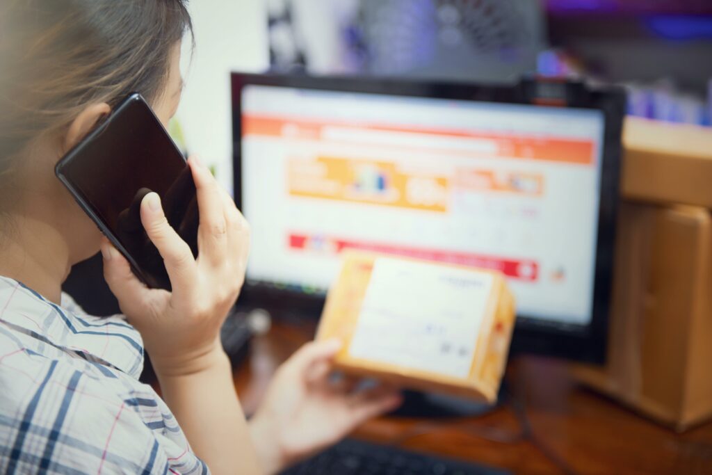 Cliente che contatta l’assistenza riguardo a un ordine dropshipping mentre controlla il pacco.